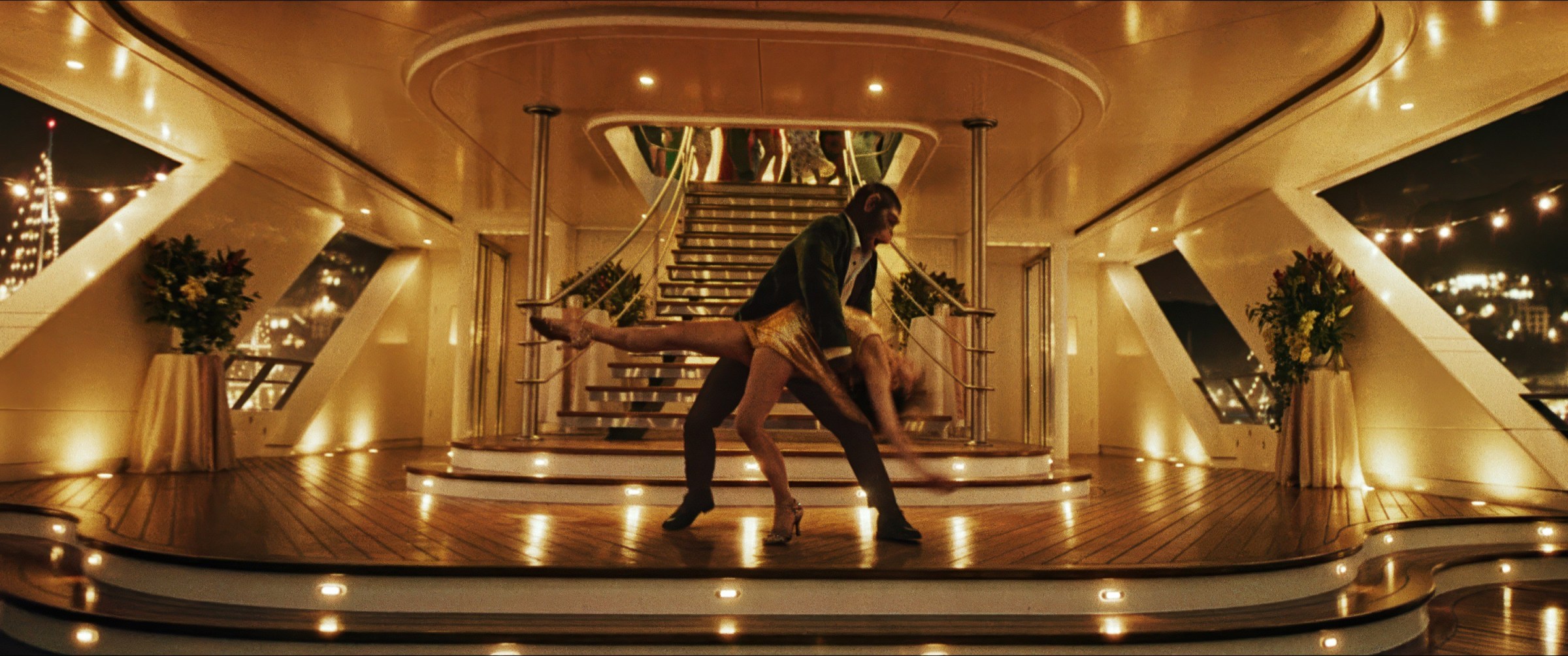 Pop star Robbie Williams (as a chimp) dips pop star Nicole Appleton (Raechelle Banno) during a pas de deux on the deck of a private yacht in Better Man